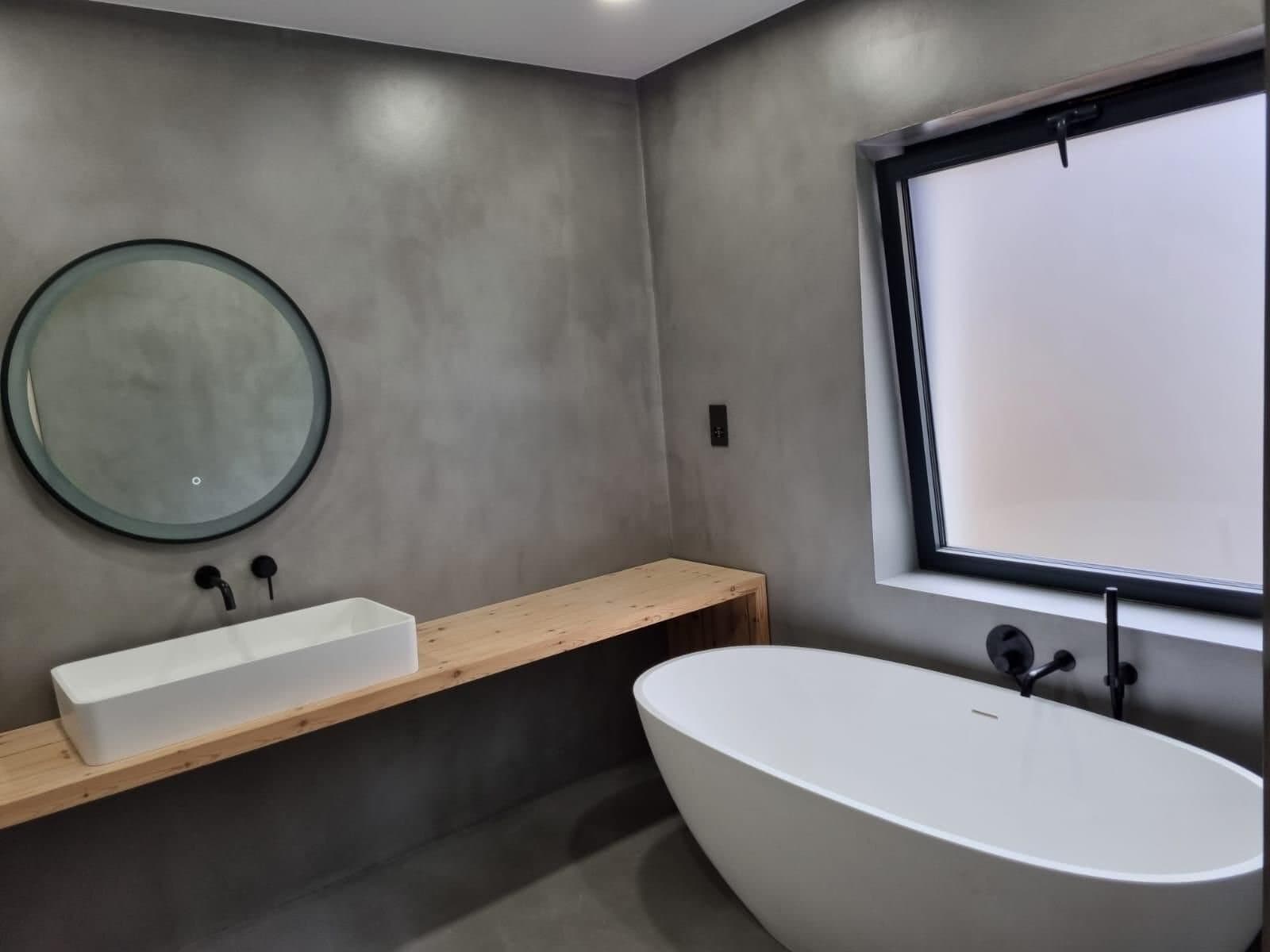 Microcement bathroom with freestanding bath and bespoke timber vanity