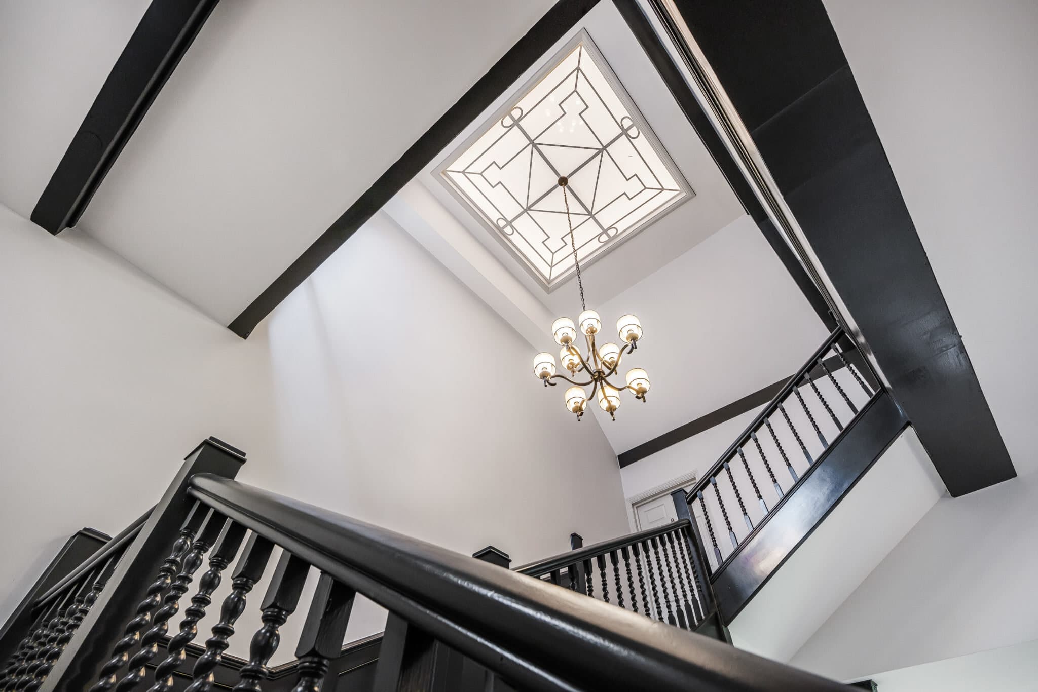 Restored galleried staircase beneath a decorative skylight